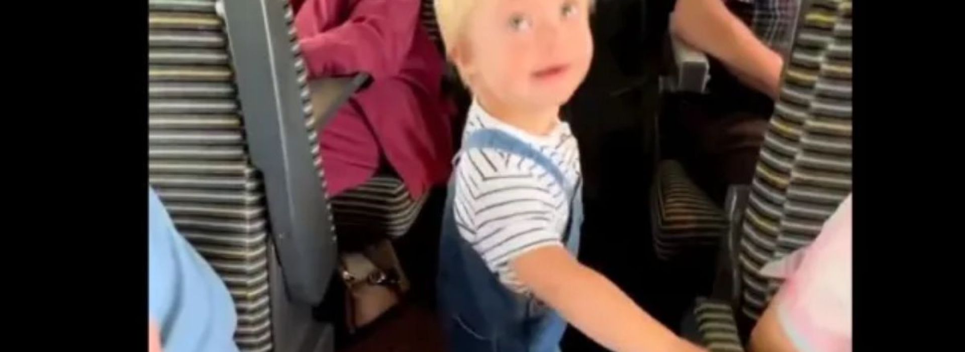Screen capture of little boy greeting passengers on a train