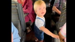 Screen capture of little boy greeting passengers on a train