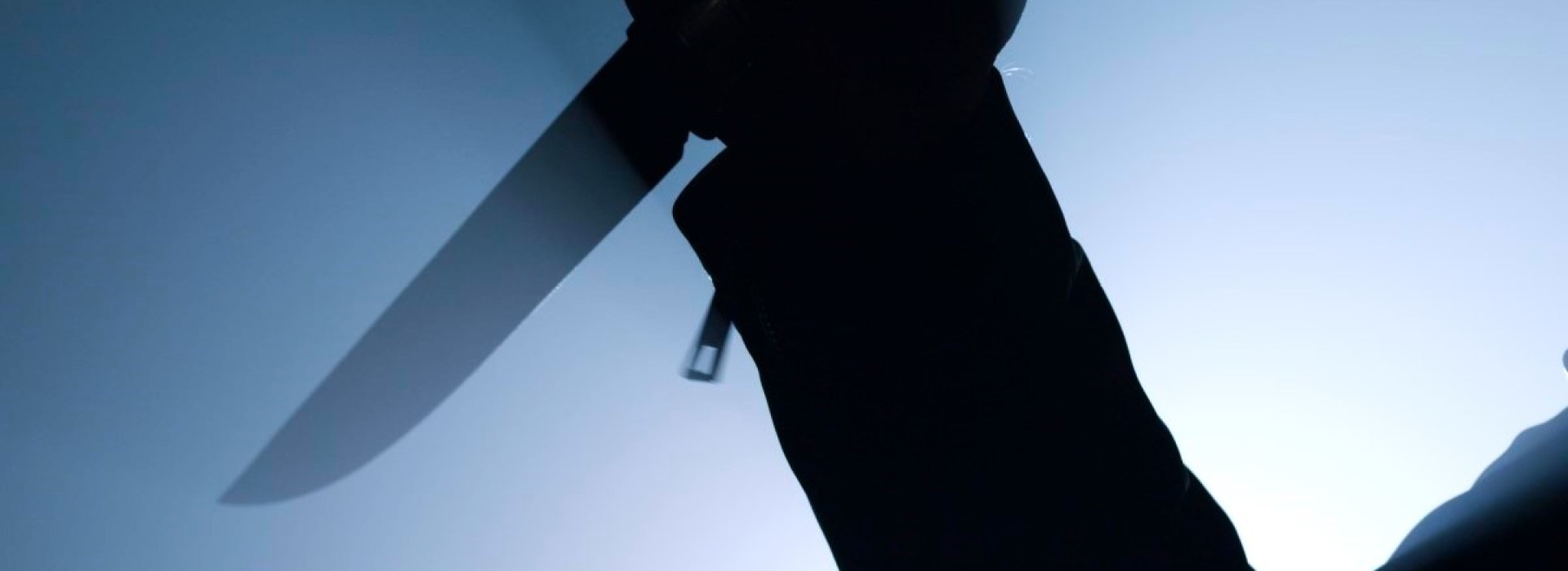 silhouette of criminal holding knife in close up