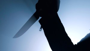 silhouette of criminal holding knife in close up