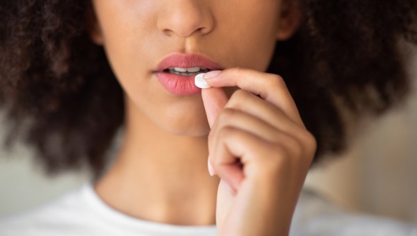 woman hesitates to take pill