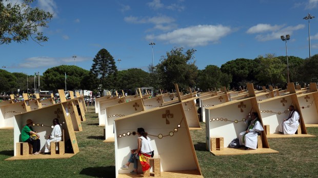 Pilgrims confess in an open confessionals area in Belem, Lisbon, during the World Youth Day