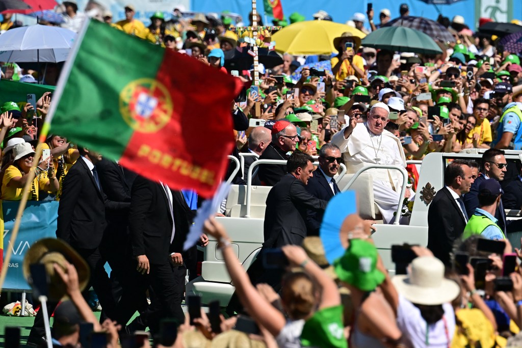 Pope Francis waves from the popemobile as he arrives for a meeting with volunteers of the World Young Day