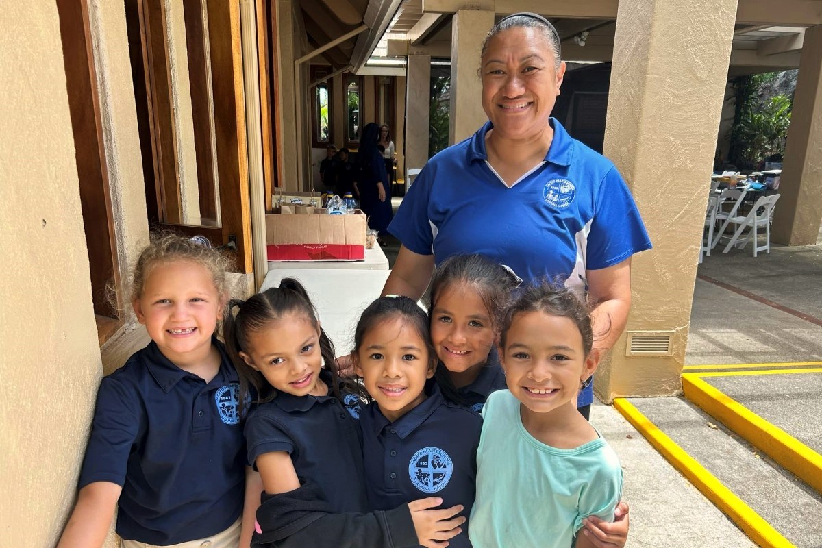 Tonata Lolesio, Principal of Sacred Hearts School, with students as the school reopens.