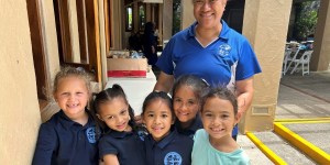 Tonata Lolesio, Principal of Sacred Hearts School, with students as the school reopens.