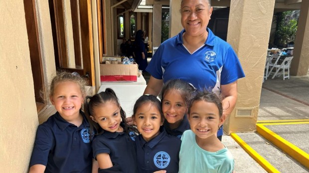 Tonata Lolesio, Principal of Sacred Hearts School, with students as the school reopens.
