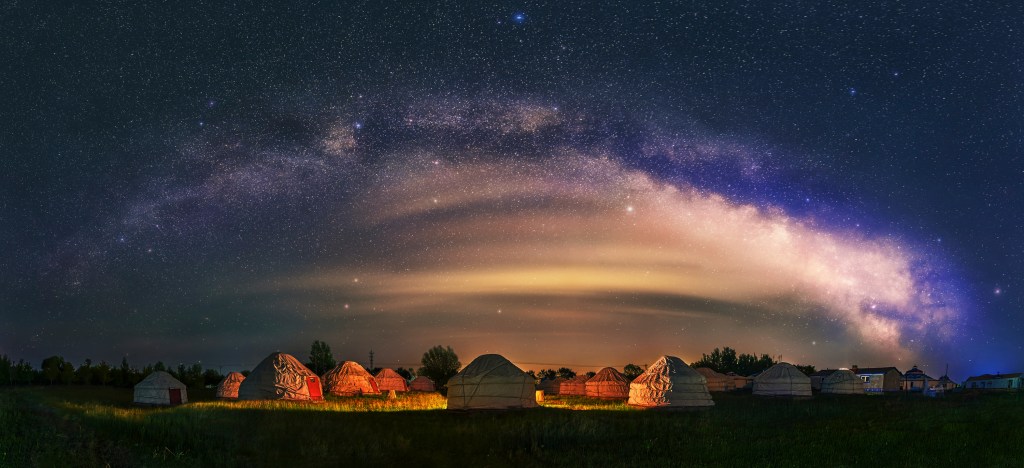 Under the bright Milky Way, Mongolia yurts on the grassland are scattered