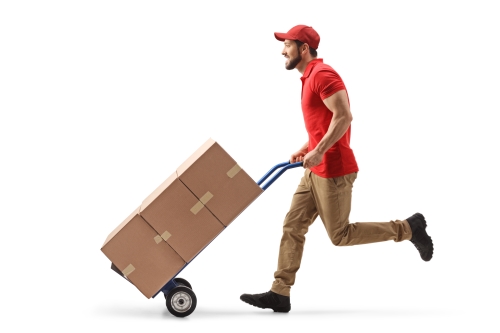 warehouse man running with cart stacked with boxes