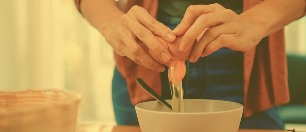 Woman's hands breaking egg