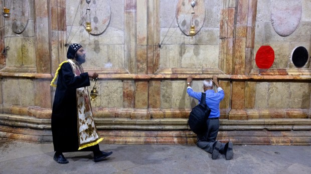 Coptic priest and layman pray in Holy Sepulcher Jerusalem