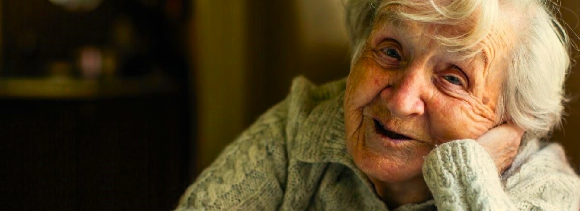 Old Irish woman leaning on window sill