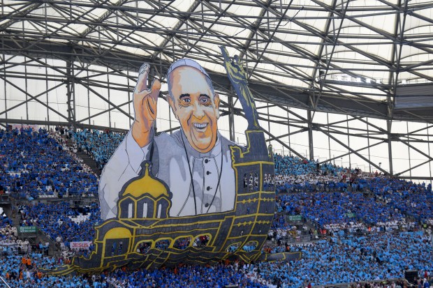 People hold up a huge banner of Pope Francis as he arrives to celebrate mass at the Velodrome stadium in the southern port city of Marseille