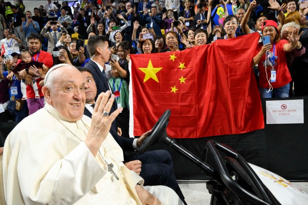 Pope Francis being driven past a Chinese flag during his arrival for Holy Mass at the Steppe Arena in Ulaanbaatar