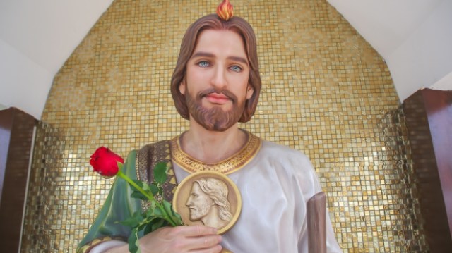 Why does St. Jude hold a medallion in paintings and statues?