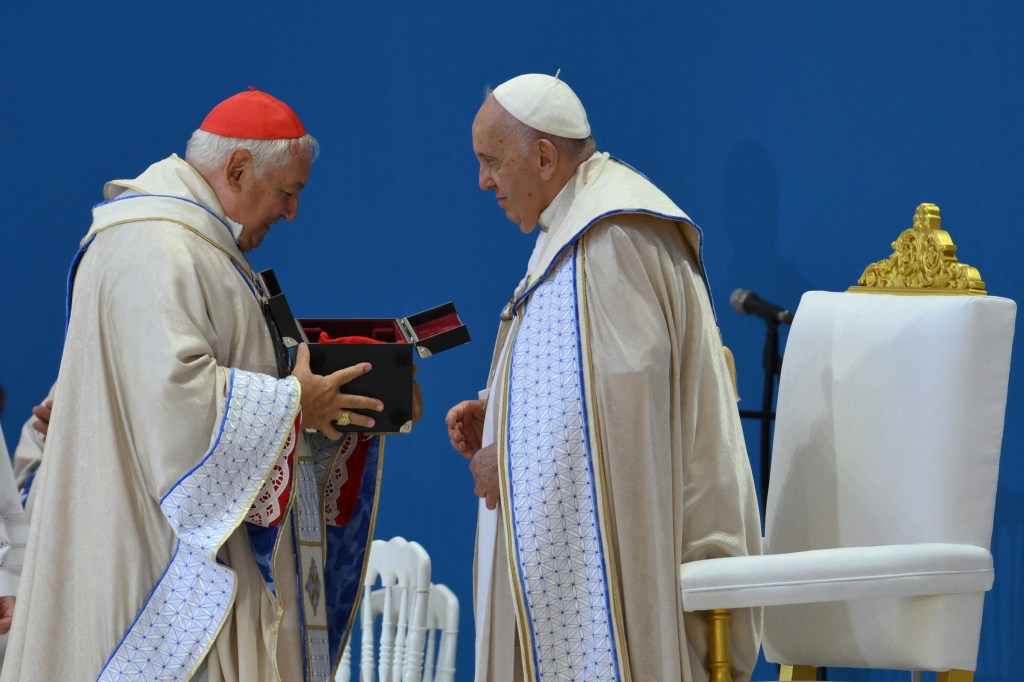 The Archbishop of Marseilles Jean-Marc Avelin offers a gift to Pope Francis during a mass inside the Velodrome stadium, in the southern port city of Marseille