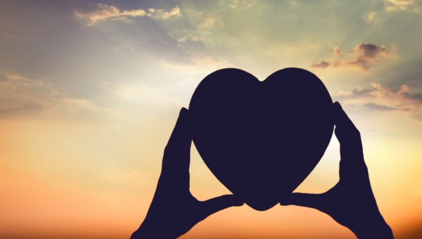 hands holding the sun at dawn