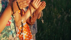 Kids hands praying rosary