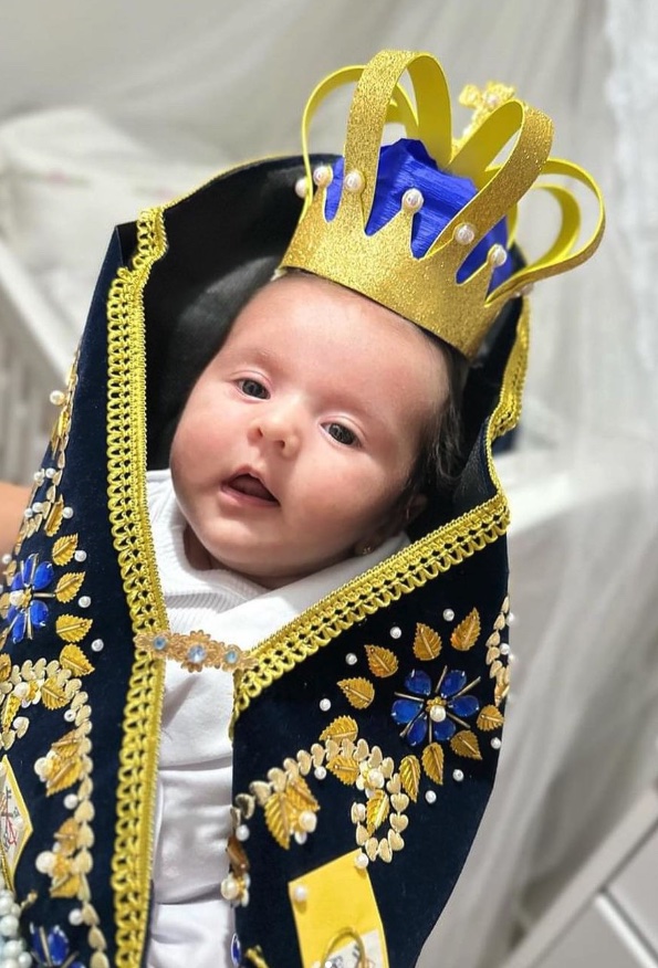 Bebê vestida com manto e coroa de Nossa Senhora Aparecida