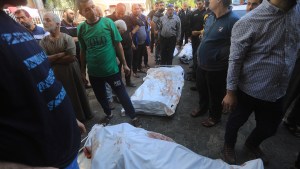 Shrouded bodies lie at site of Gaza hospital bombing