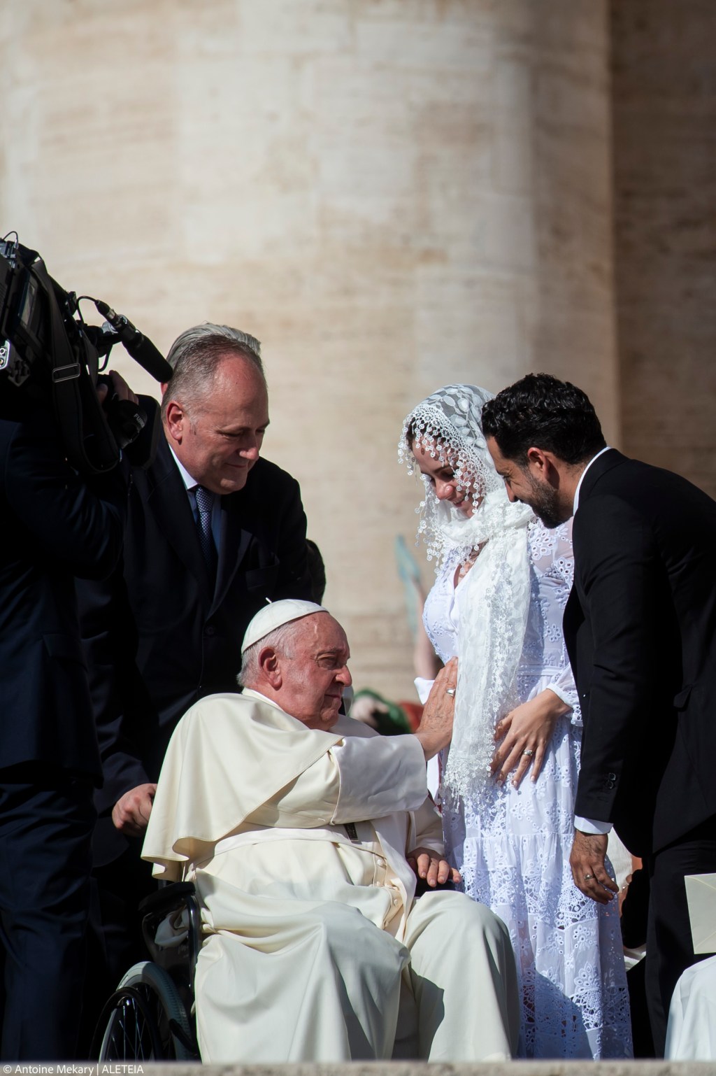 Pope Francis blesses the pregnant belly of a newlywed bride.