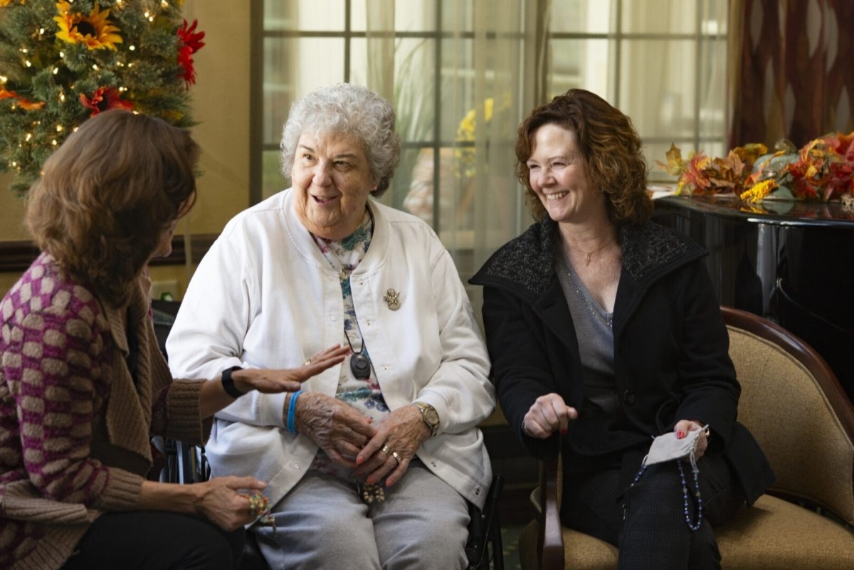 The Rosary Team members praying the rosary with an elder care patient