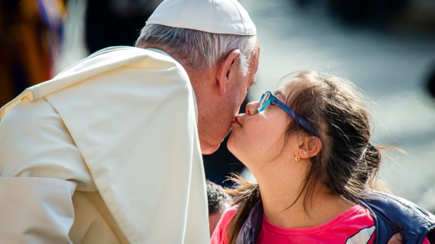A girl with down syndrome kisses Pope Francis
