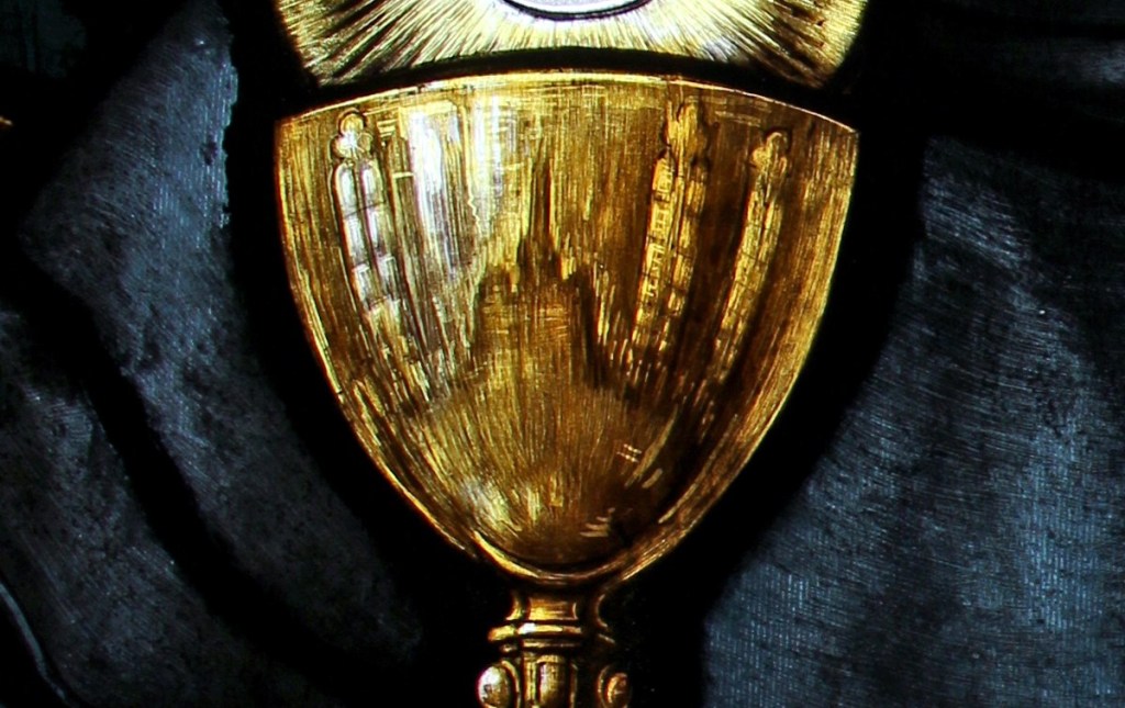 Detail of chalice held by St. Thomas, "reflecting" the nave aisle of the church.