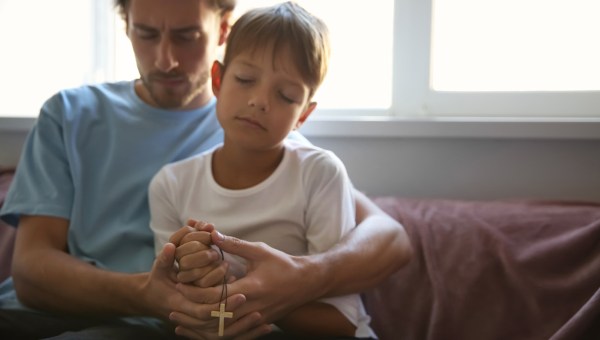 Pai e filho rezando o terço