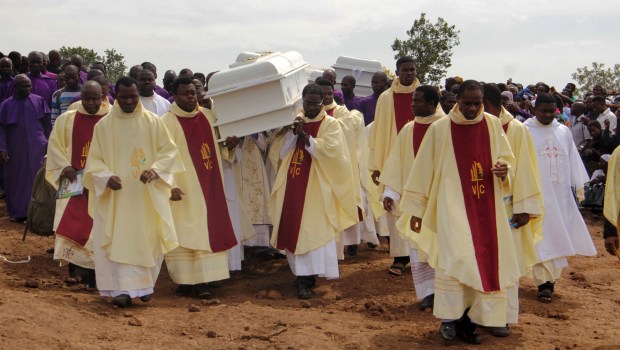 Clergymen carry white coffins containing the bodies of priests allegedly killed by Fulani herdsmen