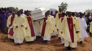 Clergymen carry white coffins containing the bodies of priests allegedly killed by Fulani herdsmen