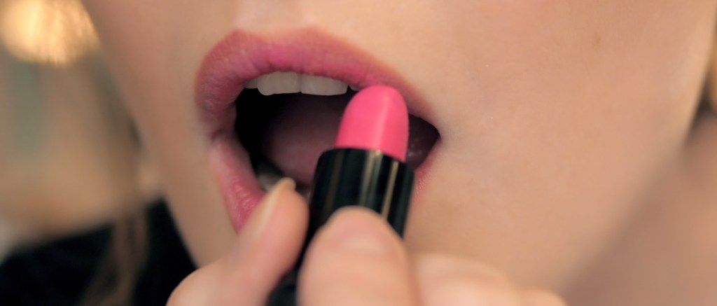 Putting on lipstick in closeup