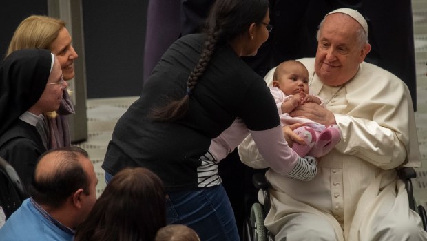 Pope Francis as he blesses a baby at the end of his weekly general audience Paul VI hall in the Vatican