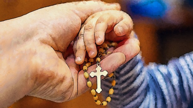 Parent handing child rosary