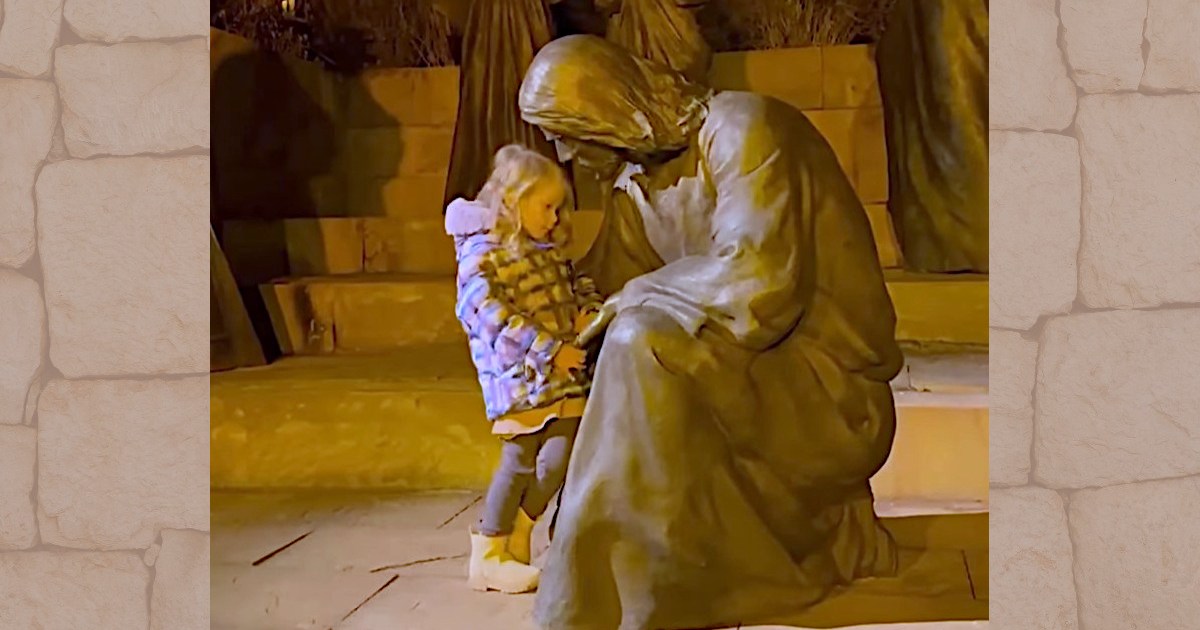 This little girl cuddling up to a statue of Jesus is simply divine!