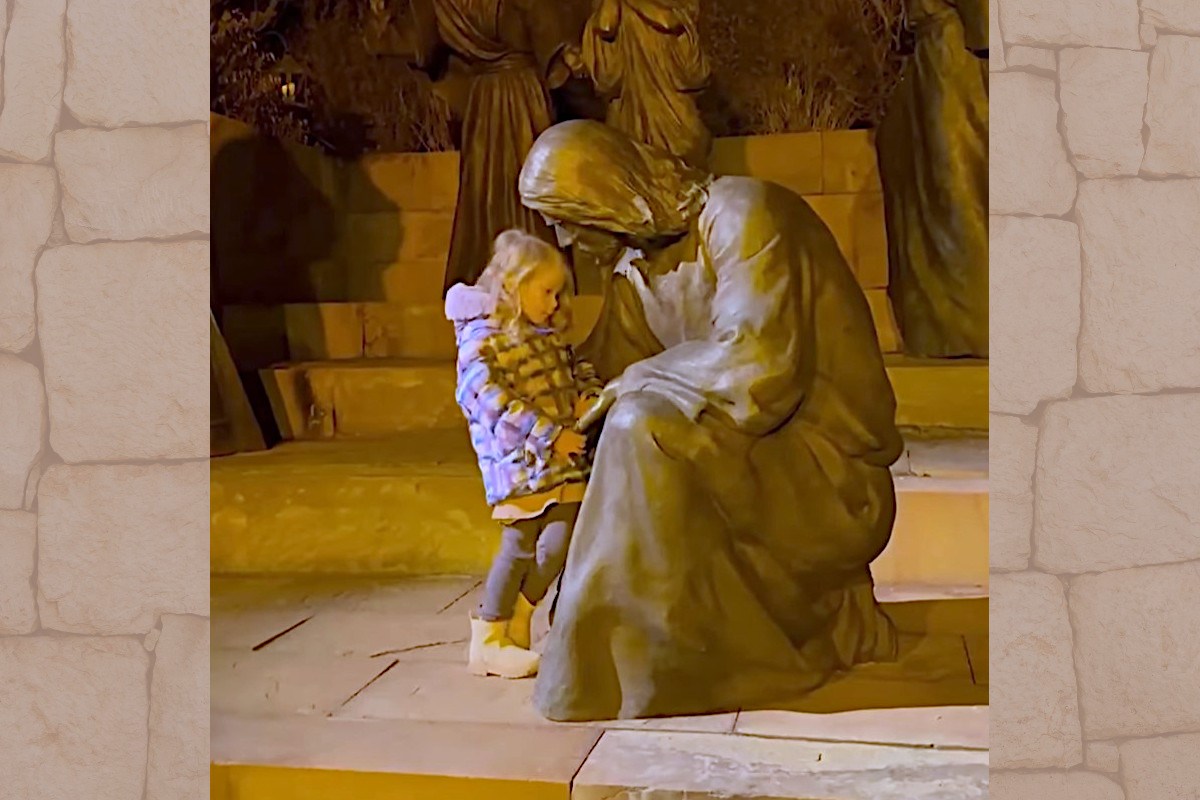 Little girl with Jesus statue