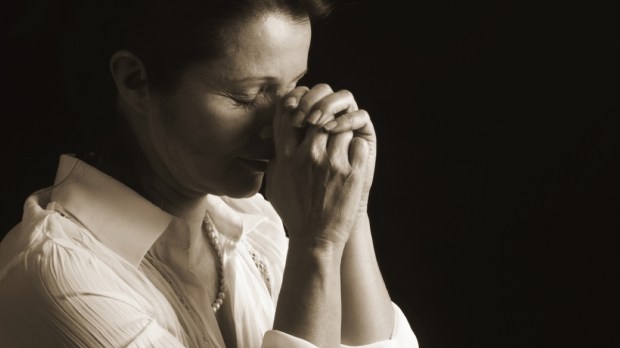 Devout woman with eyes closed in prayer