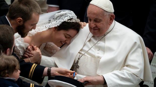 A bride leans her head on Pope Francis' shoulder during the weekly general audience on February 28, 2024 at Paul-VI hall in The Vatican.
