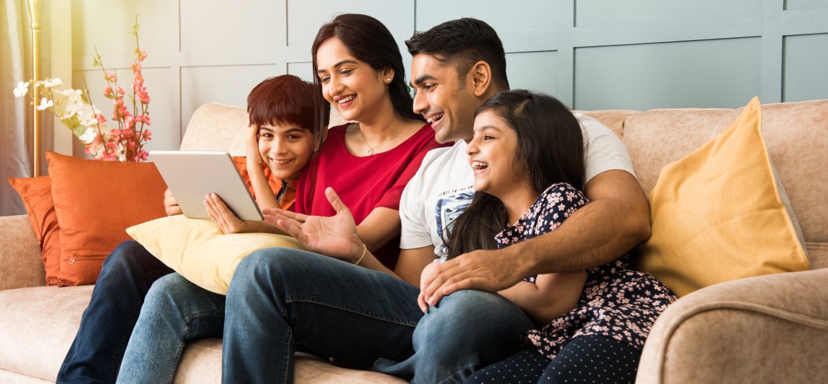 Family using smartpad on sofa