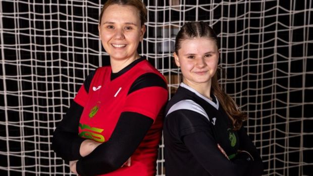 Mother and daughter stand in front of a handball goal net