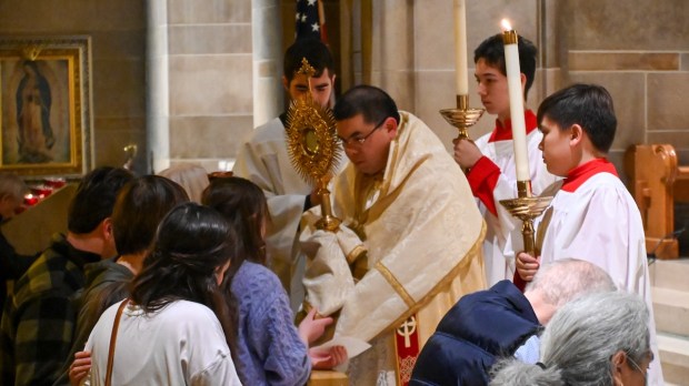 Dominican Fr. Lawrence Lew holds monstrance in Atlanta cathedral