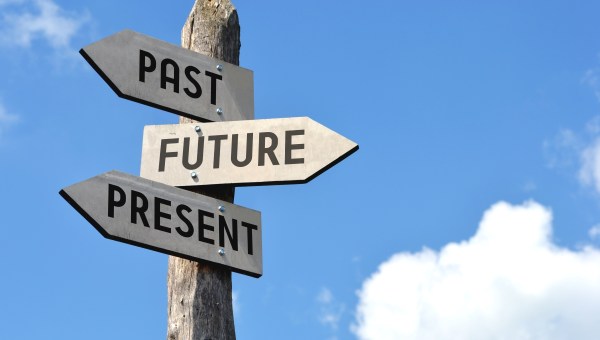 "Past, future, present" - wooden signpost, cloudy sky