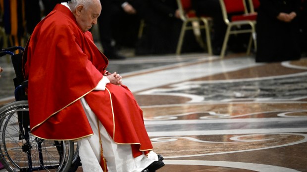 Pope Francis prays as he arrives to preside the Passion of the Lord mass on Good Friday as part of the Holy Week celebrations, at St Peter's Basilica in the Vatican on March 29, 2024