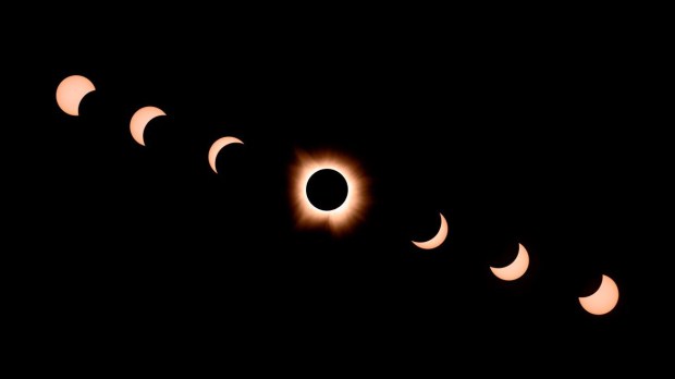 Composite of seven photographs, the moon passes by the sun during a total solar eclipse in Bloomington, Indiana, on April 8, 2024