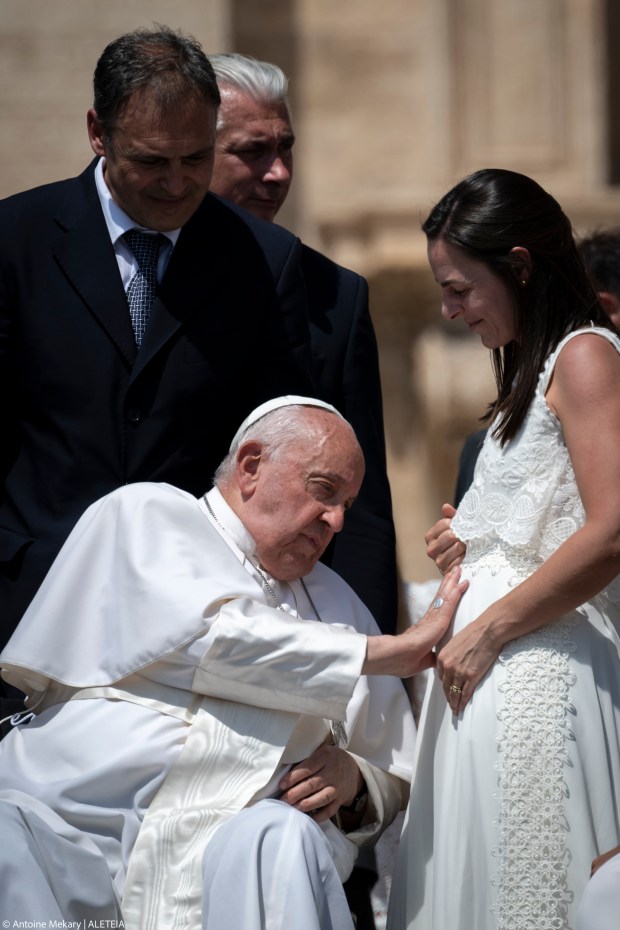 Pope Francis blesses the belly of a newlywed bride who is pregnant.