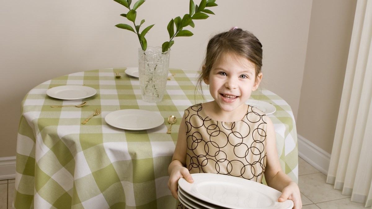 Little girl setting table