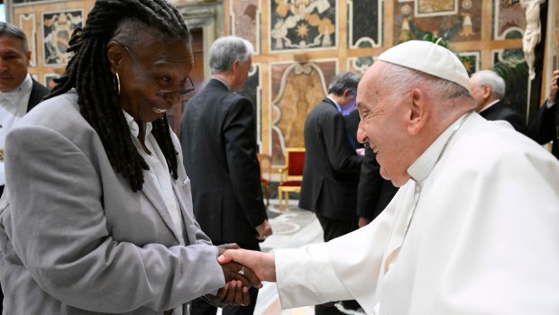 This photo taken and handout on June 14, 2024 by The Vatican Media shows Pope Francis shaking hand with US actress Whoopi Goldberg as part of an audience with comedians in The Vatican.