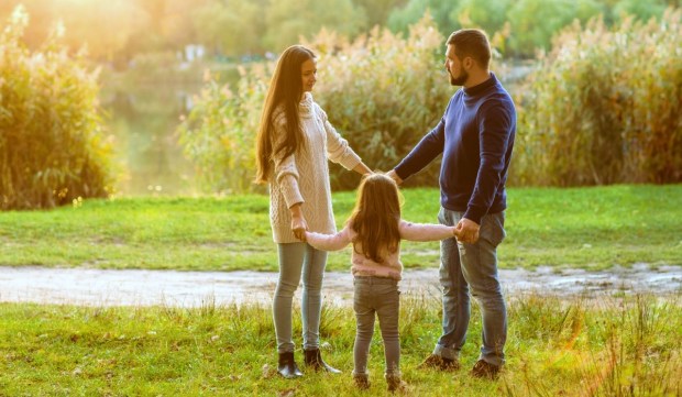Family outdoors holding hands normal