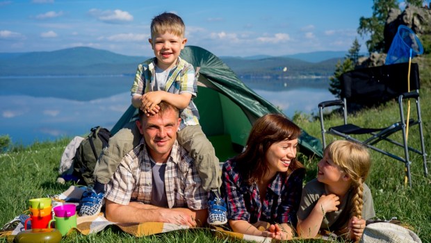 Friendly family outdoors with tent