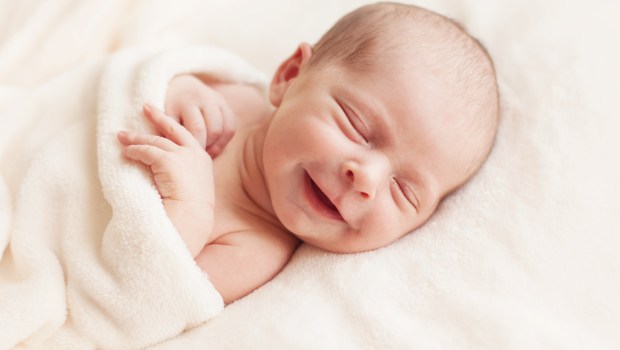 smiling newborn in white