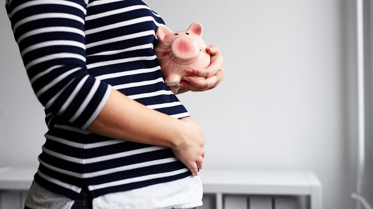 Pregnant woman with piggy bank